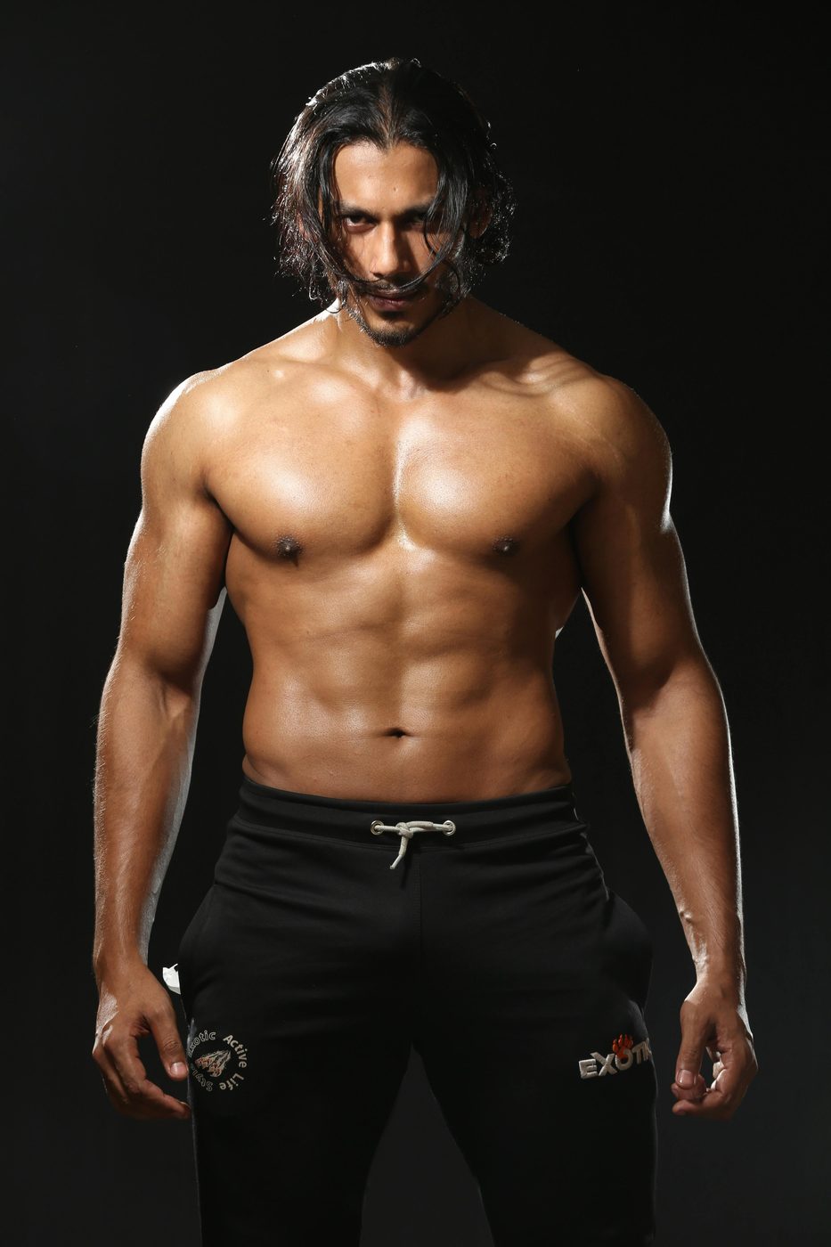 Muscular athlete lit against black