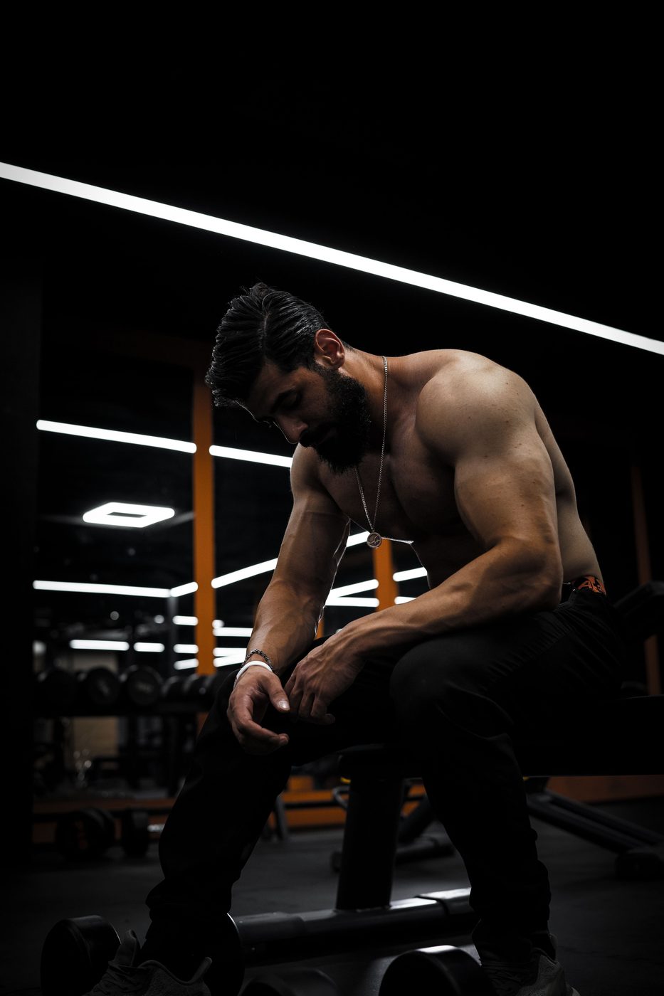 Lifter seated in a dark gym under a single light